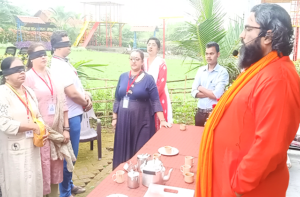 Outdoor spiritual gathering led by a saffron-robed guide