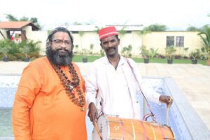 Saffron-robed spiritual guide with a devotee in a white kurta